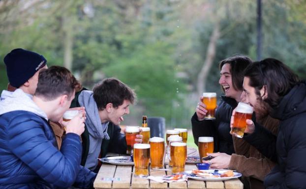 Unos jóvenes comparten unas cervezas en un pab de Londres. 