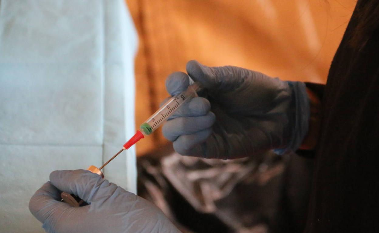 Una enfermera repara una jeringuilla con una dosis de la vacuna.