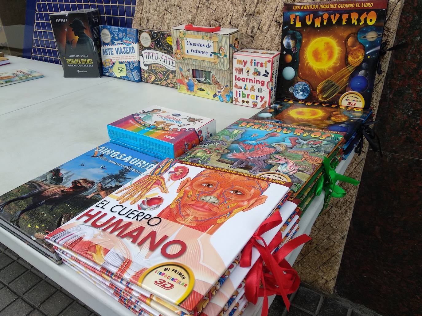 Los libros desembarcan en las calles de Ponferrada. Los libreros de la ciudad han iniciado este jueves la instalación de sus puestos a las puertas de sus establecimientos para acercar la magia de la lectura a los ciudadanos a pie de calle con motivo de la conmemoración del Día del Libro este viernes 23 de abril.