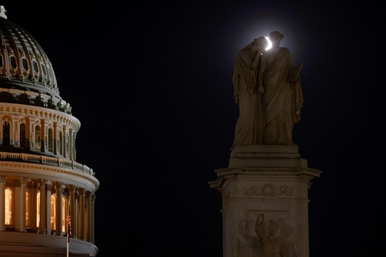 Una superluna rosa proporciona un halo detrás del Monumento a la Paz, con figuras que representan el dolor y la historia, en el Capitolio de los Estados Unidos en Washington.