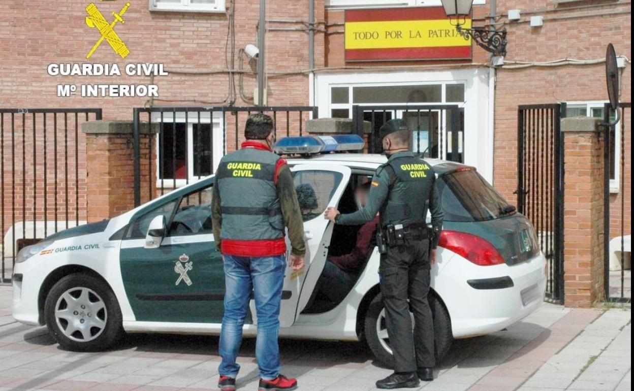 Efectivos de la Guardia Civil en el momento de introducir al detenido en el vehículo patrulla.