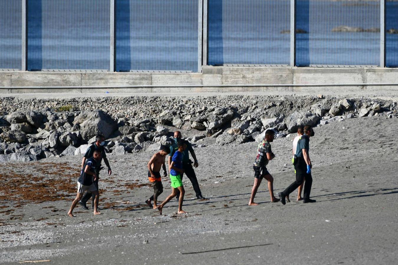 Tres guardias civiles dirigen a cinco jóvenes marroquíes hacia la zona de acogida. 