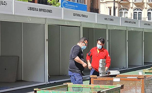 Galería. Dos operarios trabajan en la instalación de las casetas.