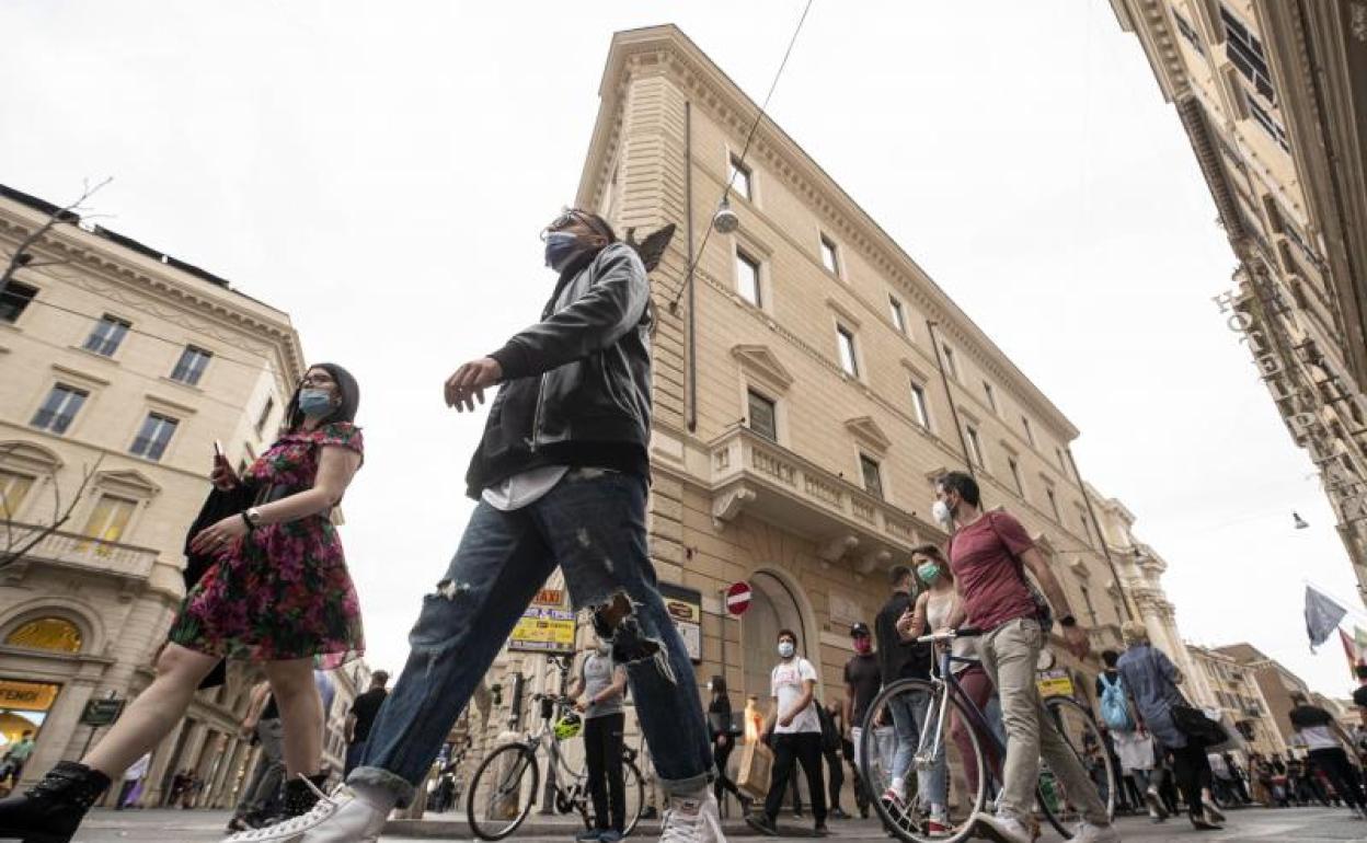 Varias personas pasean por las calles de Roma.