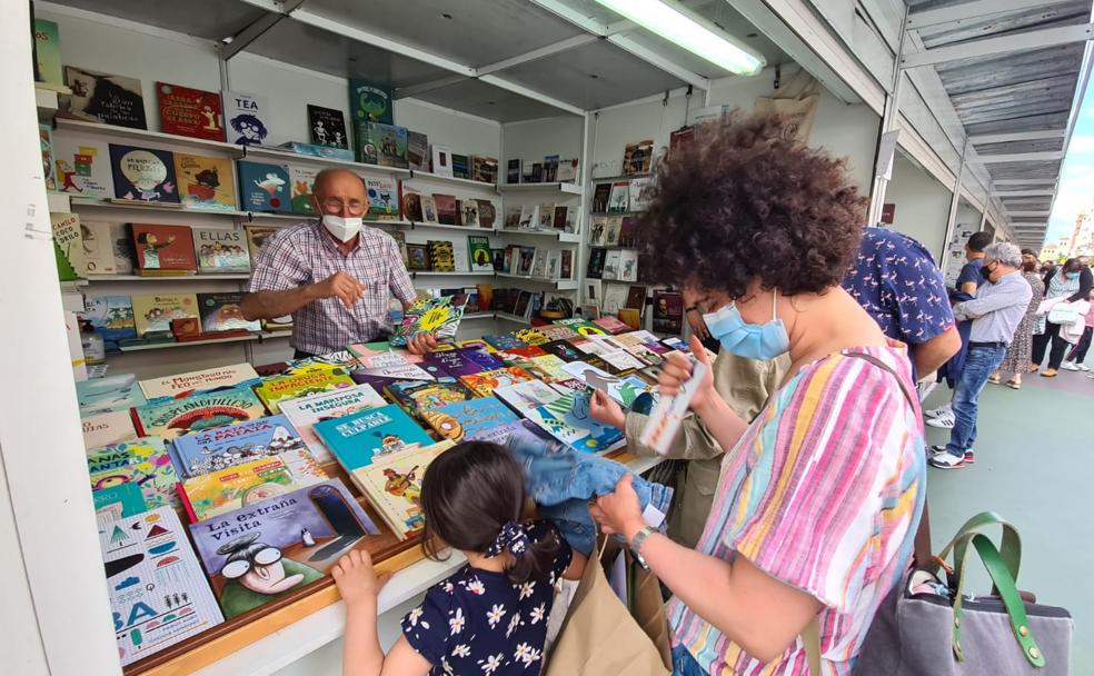 Una joven lectura busca un ejemplar en la Feria del Libro.