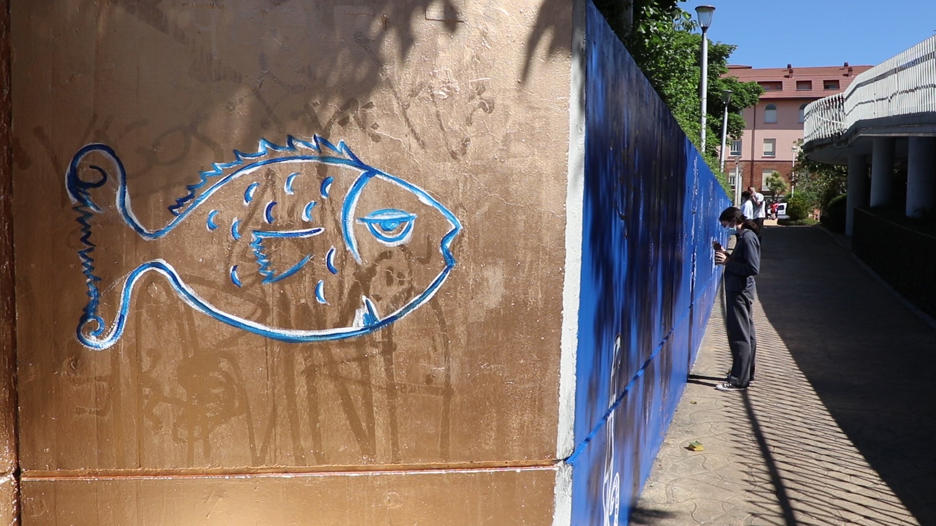 Las reconocibles figuras del fallecido artista leonés Miguel Escanciano plasman una nueva imagen en oscurecida travesía de esta calle de la ciudad, donde la colaboración entre El Corte Inglés, el artista Carlos Cuenllas y unas alumnas del Colegio Leonés y Maristas ha hecho posible dar nueva vida a un muro sin estética.