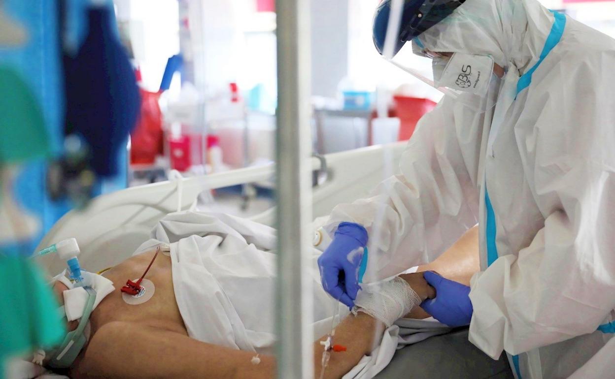 Una sanitaria atiende a un paciente covid en una UCI. 