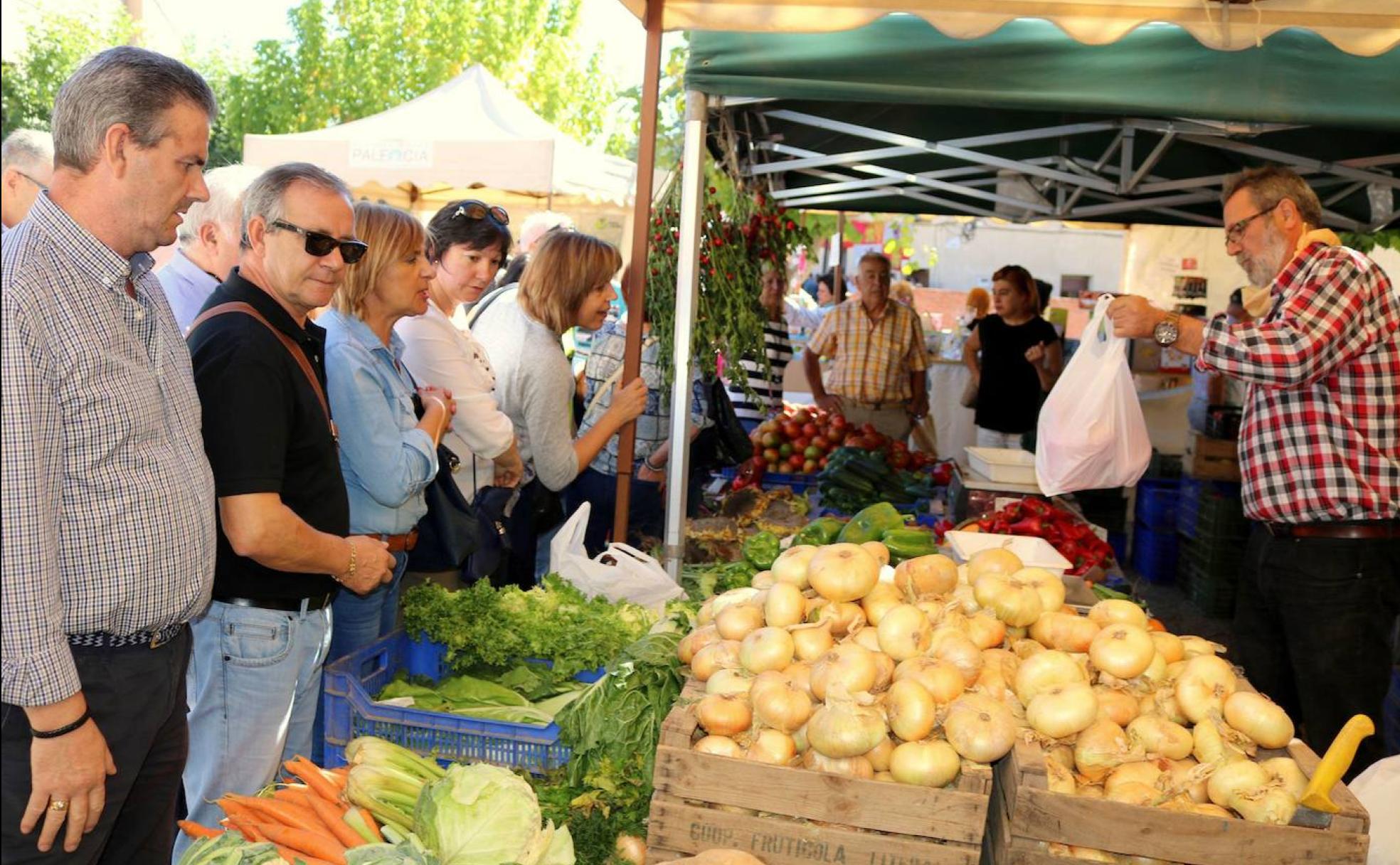 Varios visitantes ojean los productos de la huerta en la Feria de la Cebolla horcal.