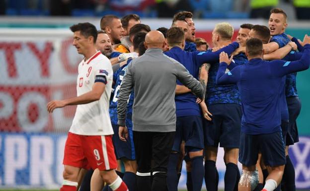 Robert Lewandowski cabizbajo, mientras los eslovacos celebran el triunfo. 