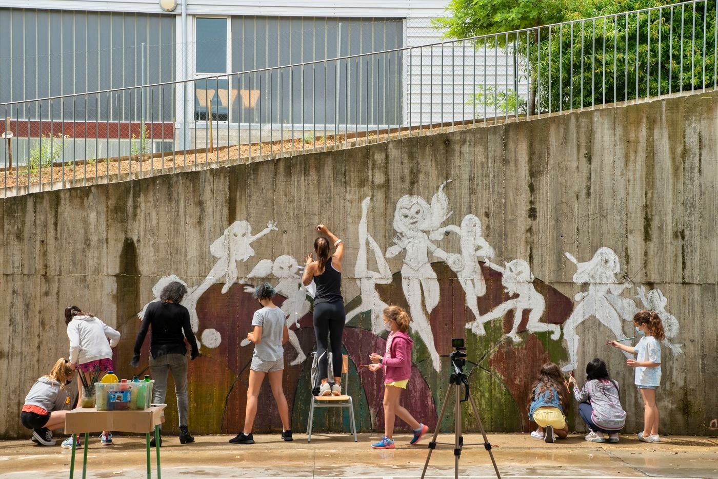 Un mural de superheroínas visibilizará el deporte femenino en el CEIP Margarita Salas de Arroyo (Valladolid), centro vencedor del reto de Afedecyl, impulsado por Iberdrola. En la imagen las niñas que están pintando el mural, junto a los responsables de la iniciativa y profesoras del centro; entre ellos, el dibujante leonés 'lolo'. 