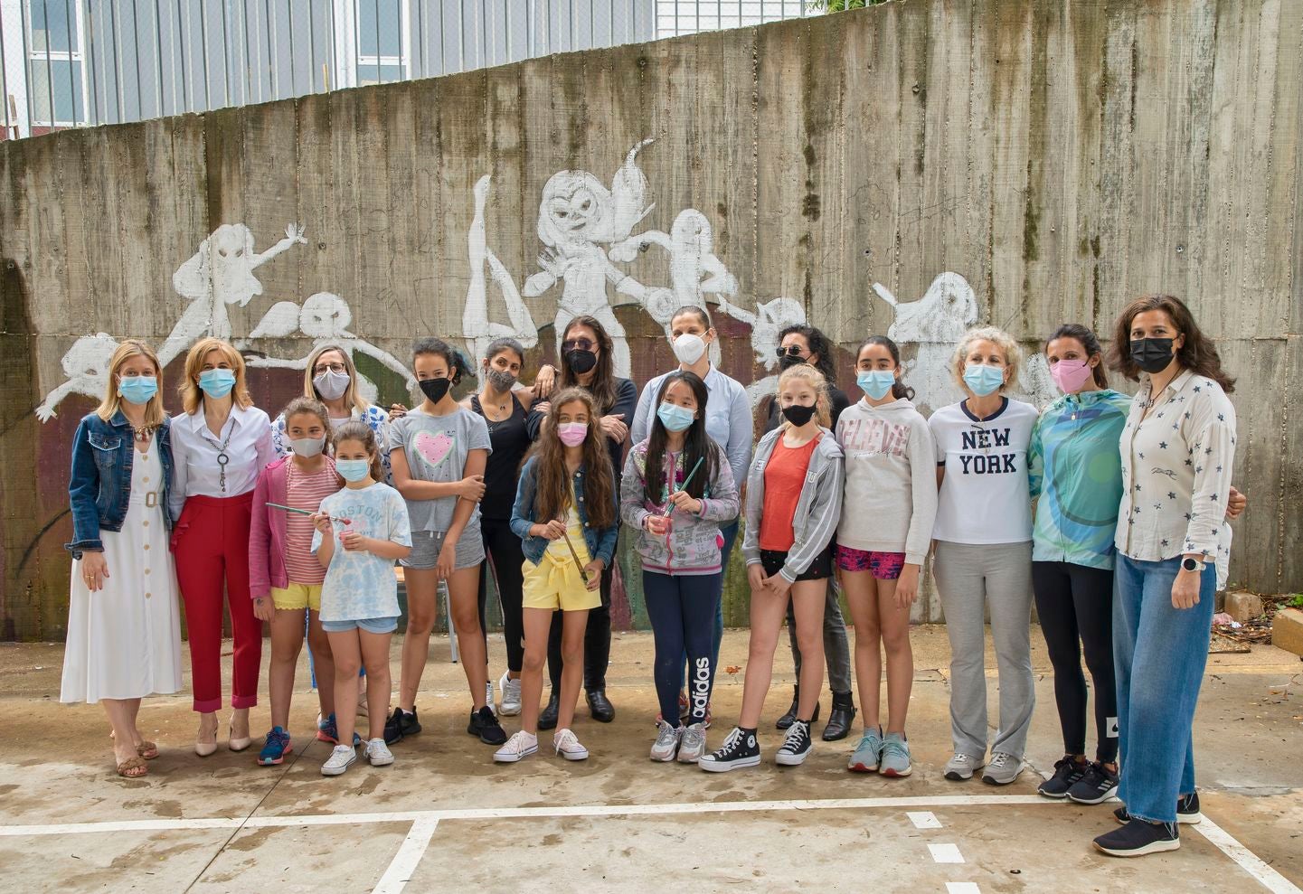 Un mural de superheroínas visibilizará el deporte femenino en el CEIP Margarita Salas de Arroyo (Valladolid), centro vencedor del reto de Afedecyl, impulsado por Iberdrola. En la imagen las niñas que están pintando el mural, junto a los responsables de la iniciativa y profesoras del centro; entre ellos, el dibujante leonés 'lolo'. 