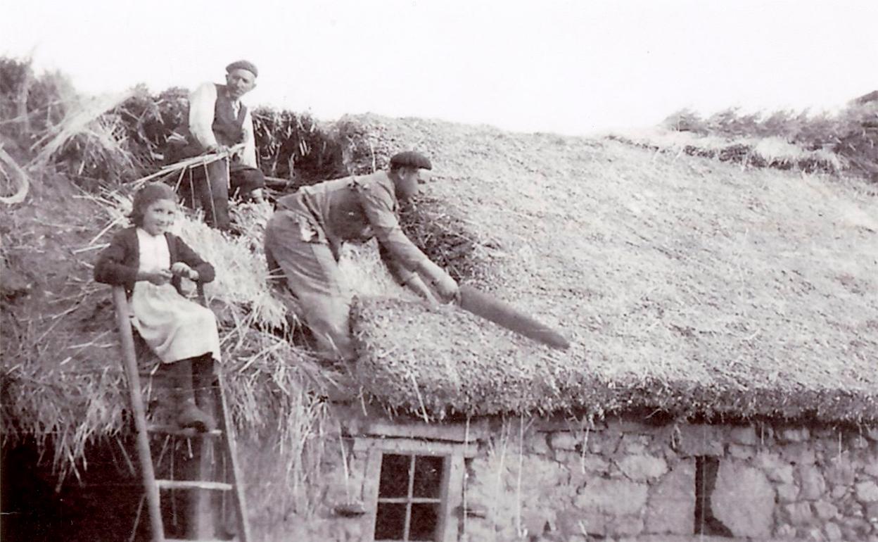 El techador de Benamarías, Pablo, techando en Sueros la casa de Floro, en presencia de Marina la hija de este último, hacia 1950.