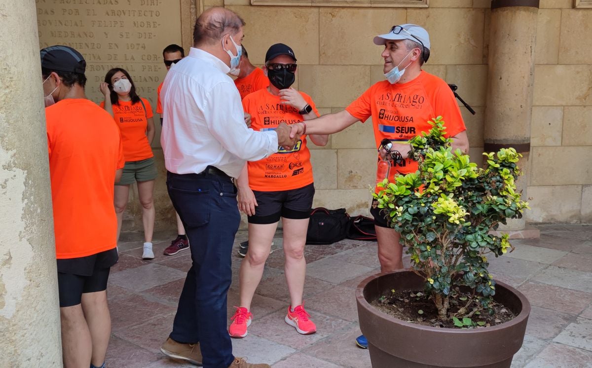 Dos corredores de posan junto a sus nietos a su llegada al Palacio de los Guzmanes.