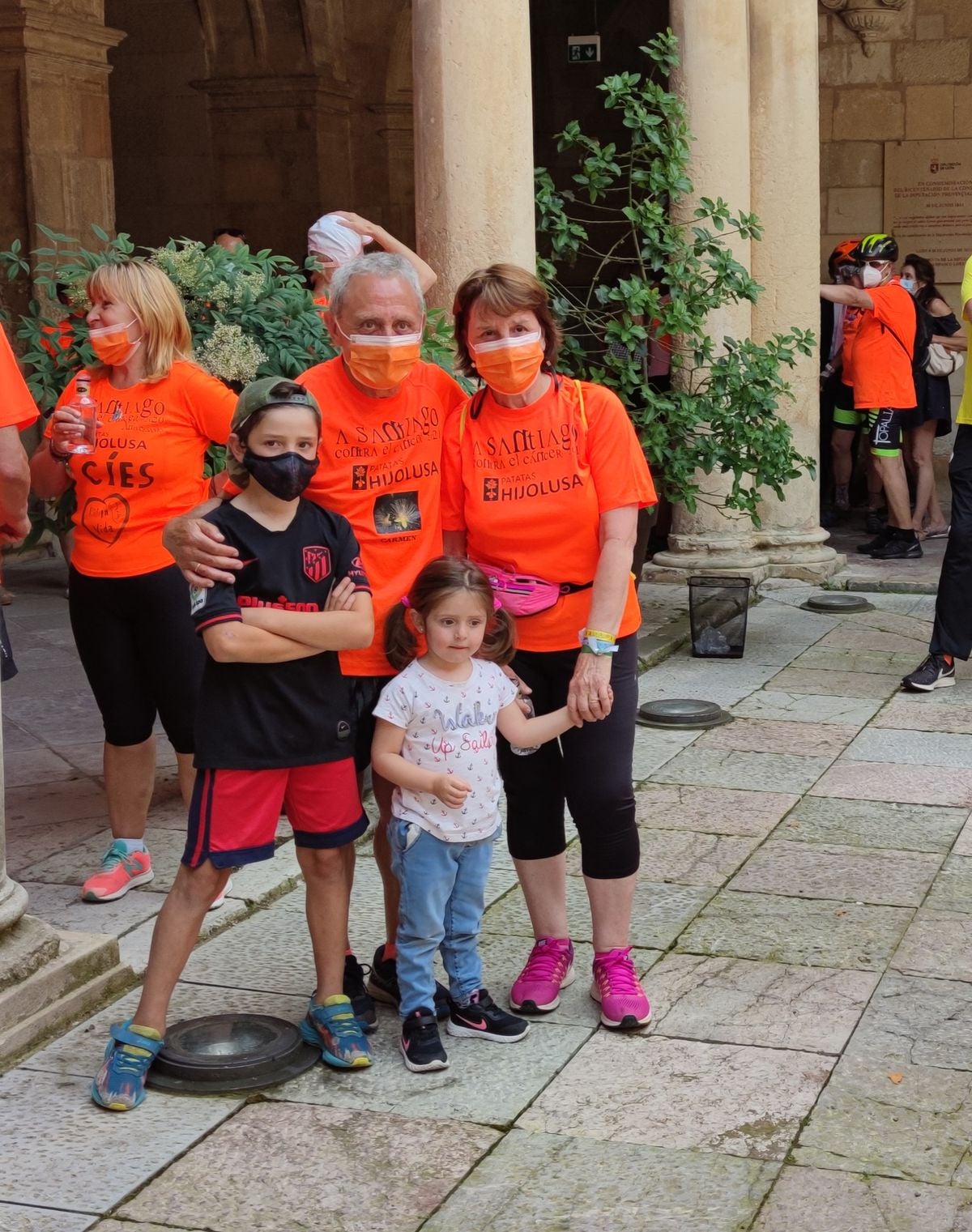 Dos corredores de posan junto a sus nietos a su llegada al Palacio de los Guzmanes.