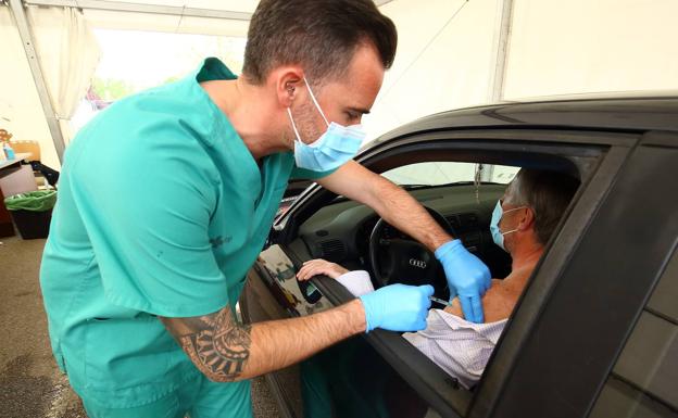 Una profesional sanitario vacuna a un ciudadano. 