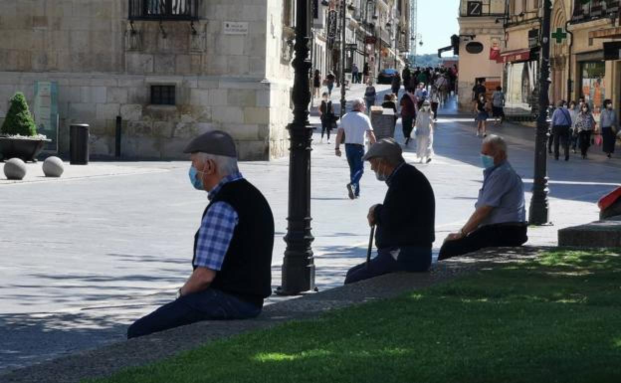 Unos señores descansan a la sombra en León. 