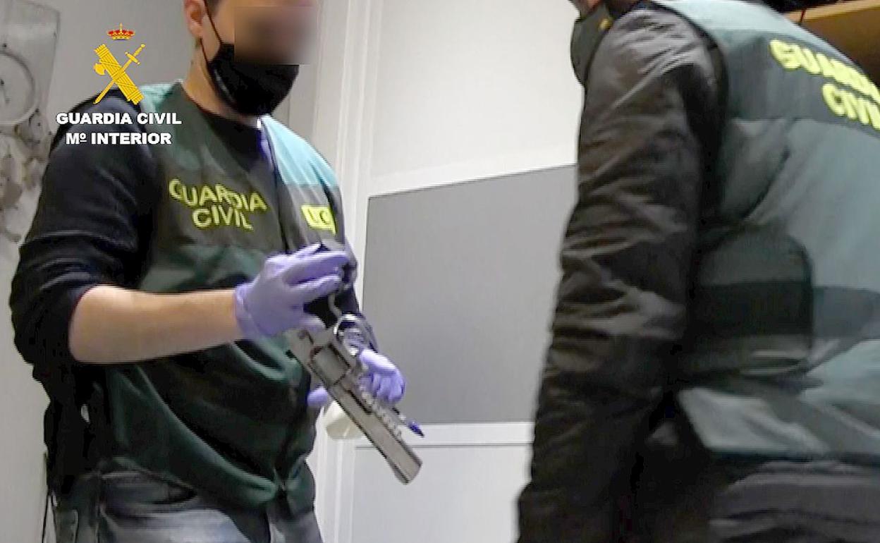 Efectivos de la Guardia Civil examinan una de las armas incautadas. 