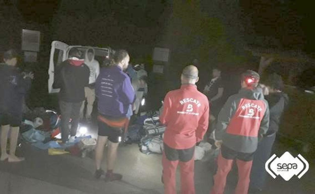 Los jóvenes scouts rescatados en los Lagos junto a efectivos del SEPA, durante la noche del miércoles en el parking del lago Ercina.