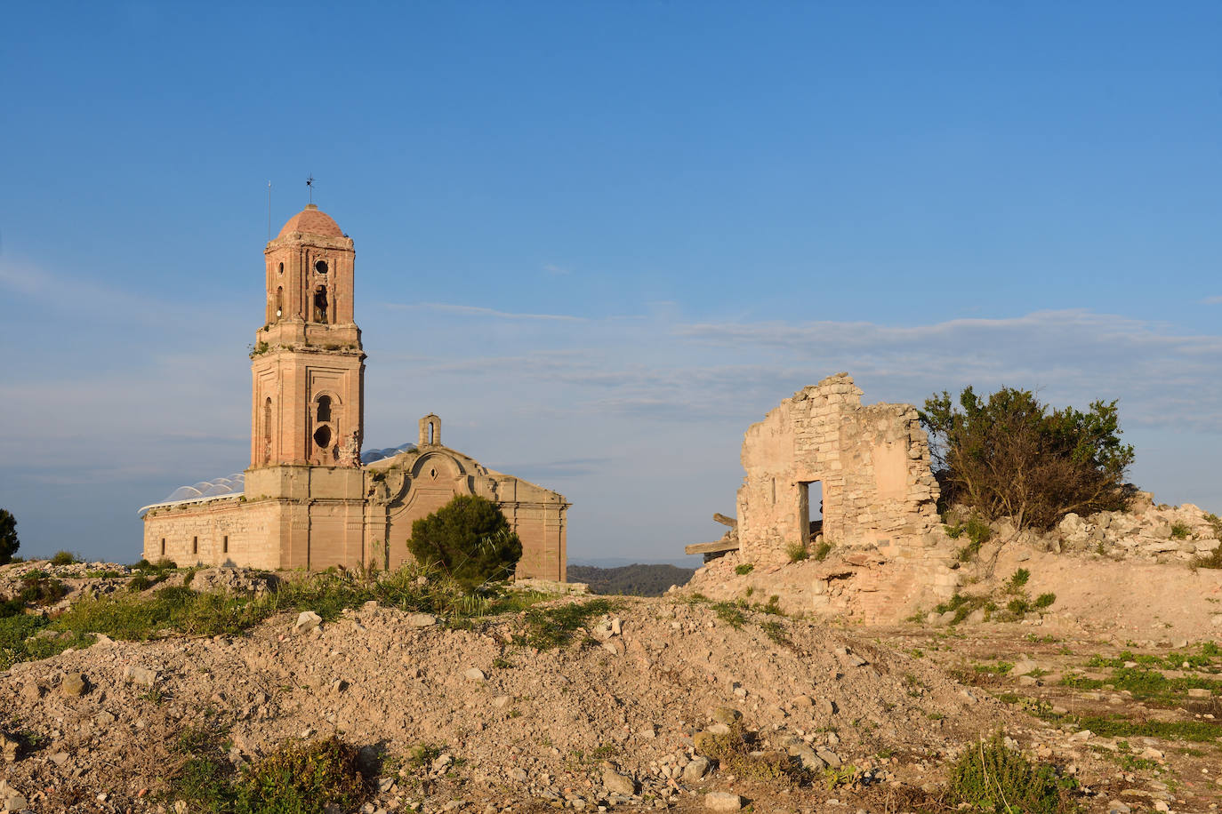 11. Corbera d’Ebre (Tarragona). Se trata de un pueblo retraro casi exacto de cómo quedó el pueblo tras la guerra. De cuánto sufrió su población. Fue un pueblo pequeño, agrícola, ubicado en la zona en la que se desarrolló la batalla del Ebro. Quedó arrasado. Bajo la Muntera, la loma sobre la que se asentaba, las familias formaron un pueblo nuevo. Del viejo y martirizado asentamiento destacan tanto el silencio como la vieja iglesia de Sant Pere, del s. XVIII. En 1992 se declaró Bien de Interés Cultural.