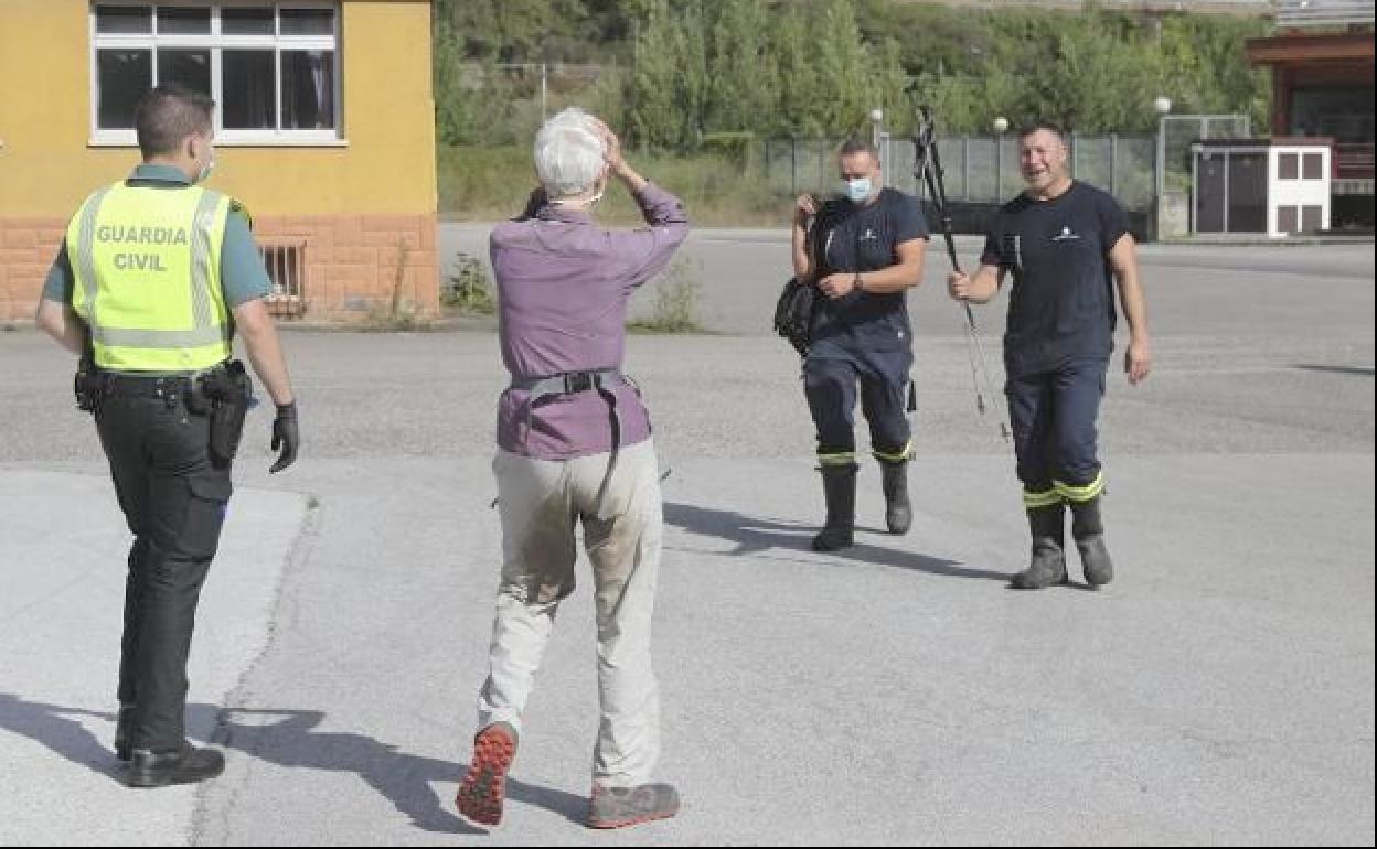 BOmberos de Asturias entregan a la peregrina sus bastones para caminar tras el rescate. 