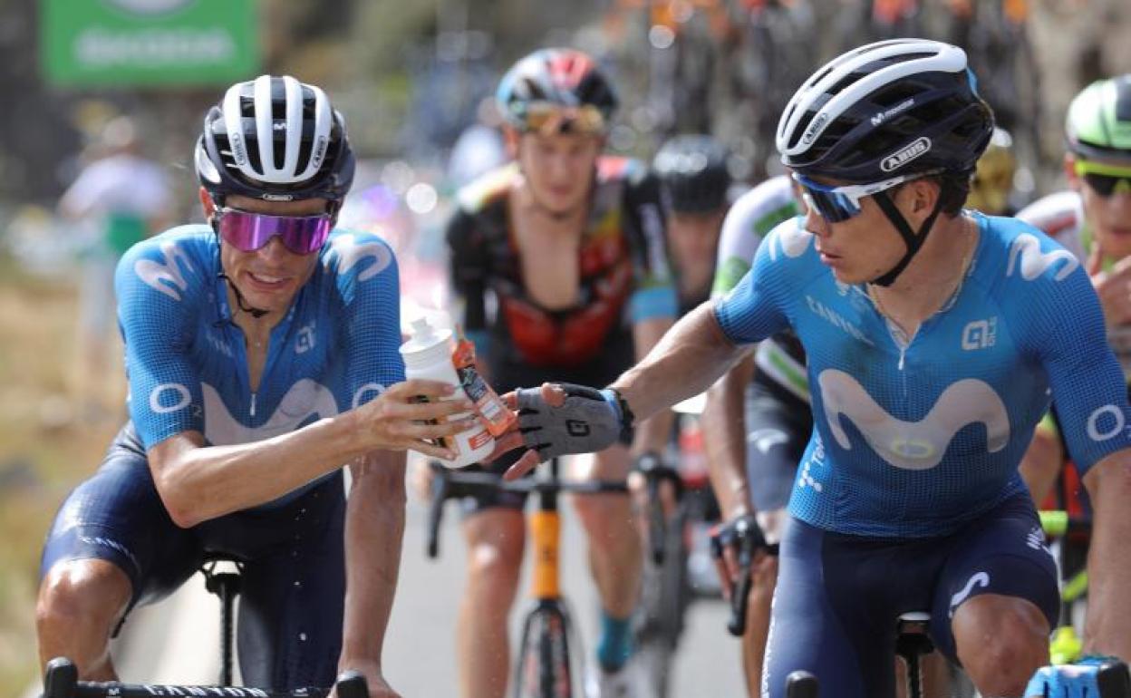 Enric Mas le pasa un bidón a Superman López en la pasada Vuelta a España. 