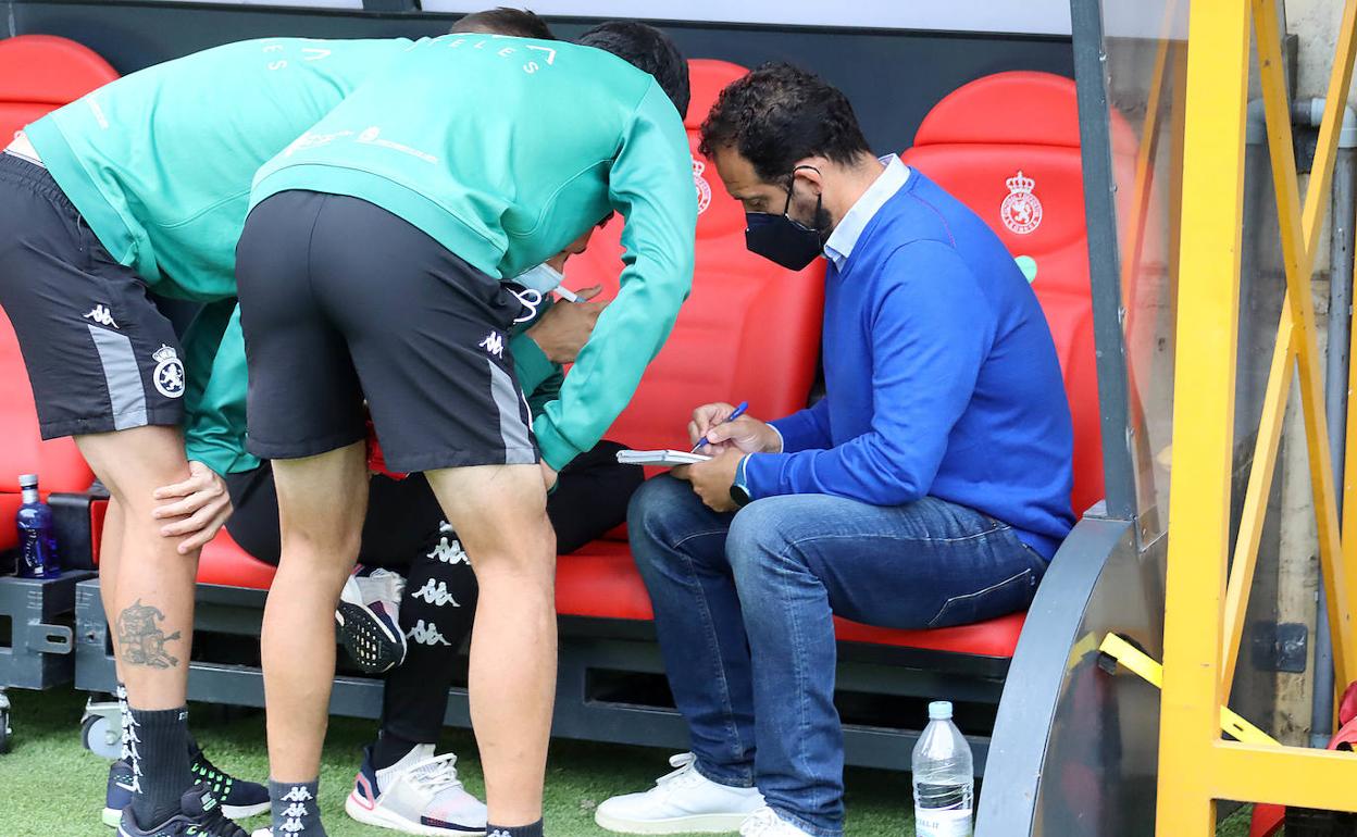 Ramón González conversa con su cuerpo técnico durante el descanso.