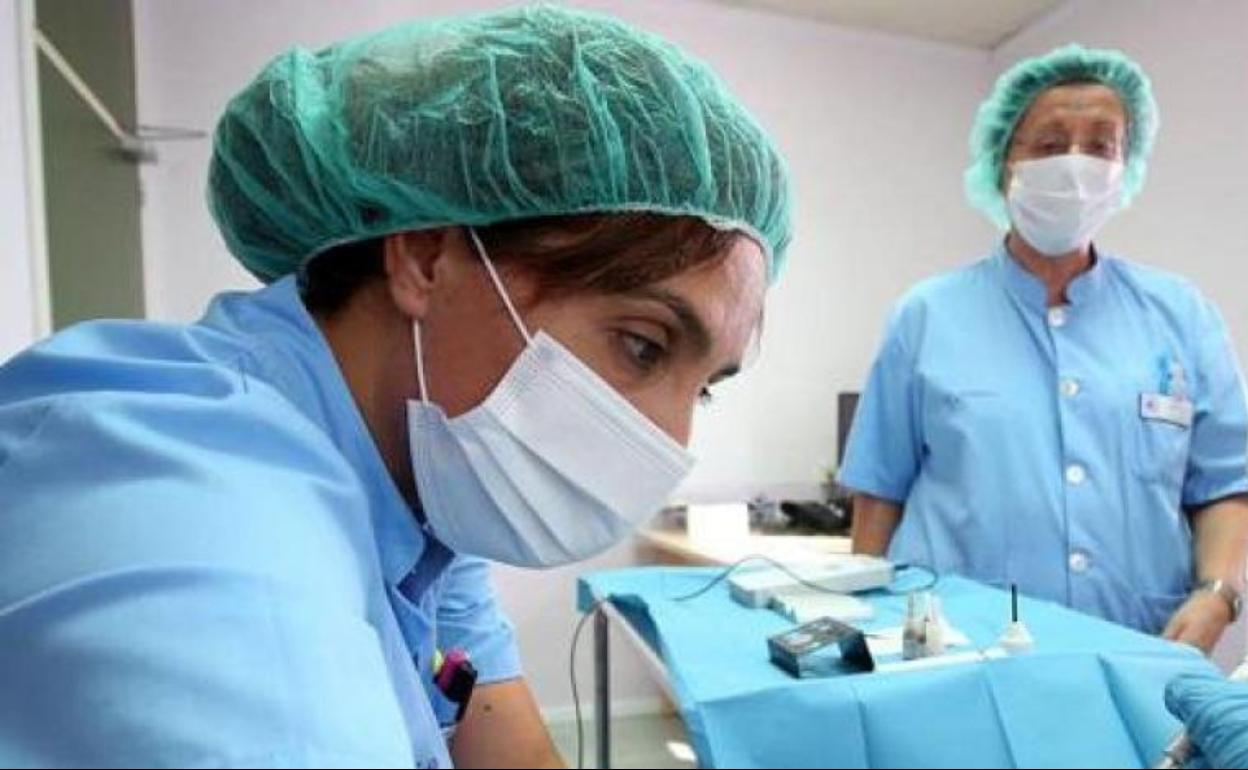 Dos enfermeras atienden a un paciente durante la pandemia.