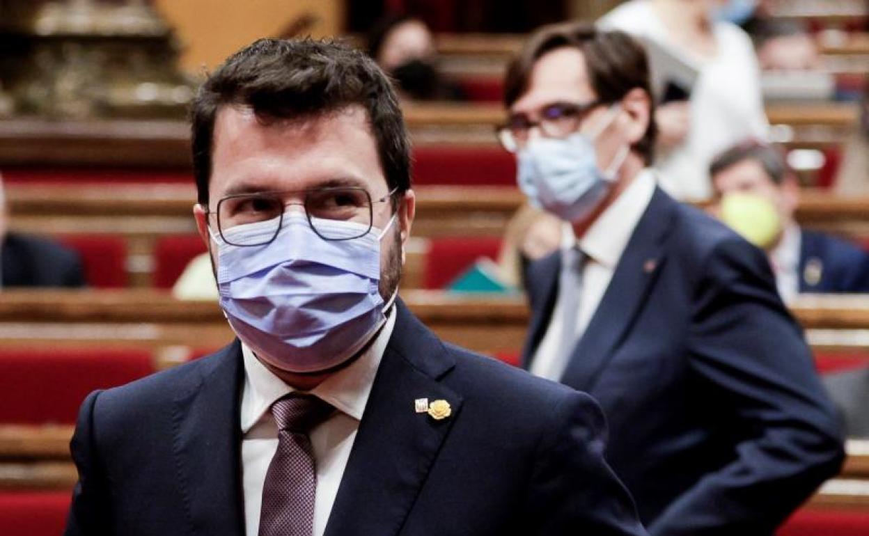 El presidente de la Generalitat, Pere Aragonés, y al fondo el lider del PSC, Salvador Illa