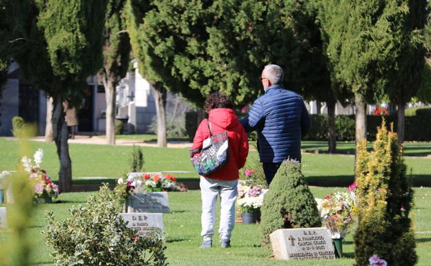 Imagen. Una pareja visita la tumba de sus familiares. 