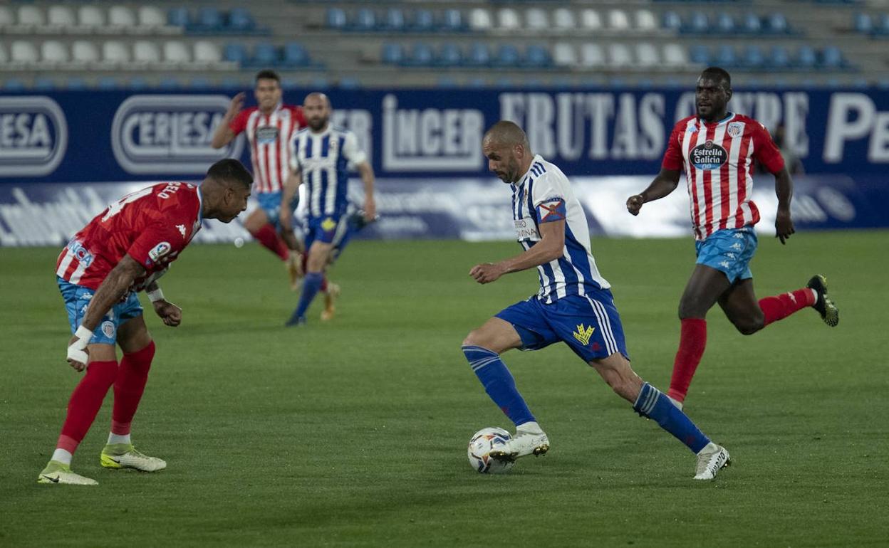 Yuri encara a un rival en el último duelo entre Lugo y Deportiva de la pasada temporada.