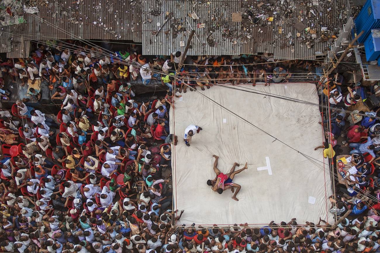 ‘Lucha callejera’, por Anupam Roy Chowdhury. Los luchadores locales luchan en un combate dentro del área del mercado Raja Katra en el barrio de Burrabazar. El torneo es organizado todos los años por el Burrabazar Bayam Samity con motivo del Diwali, uno de los festivales más importantes de la India. Cientos de personas se dieron cita para participar del evento deportivo.