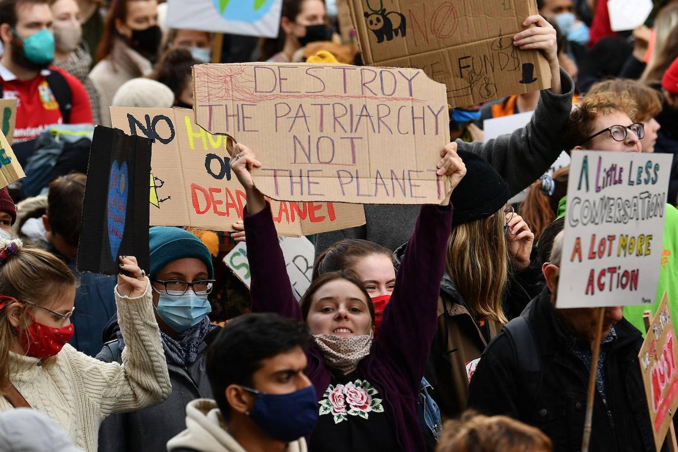 Una joven muestra una pancarta en la que se puede leer «destruir el patriarcado no el planeta»