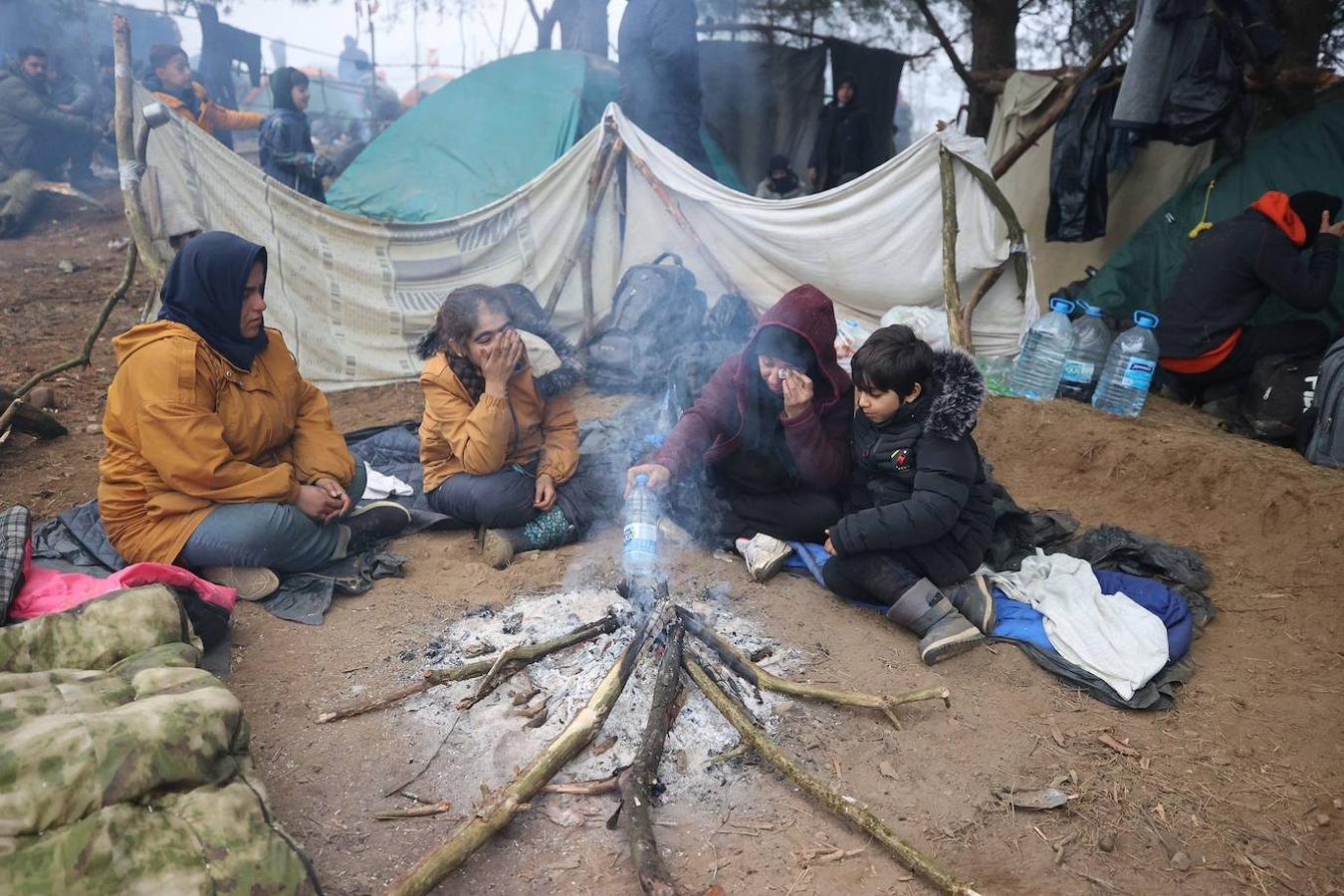 Una familia alrededor de una hoguera esperando para pasar a Polonia