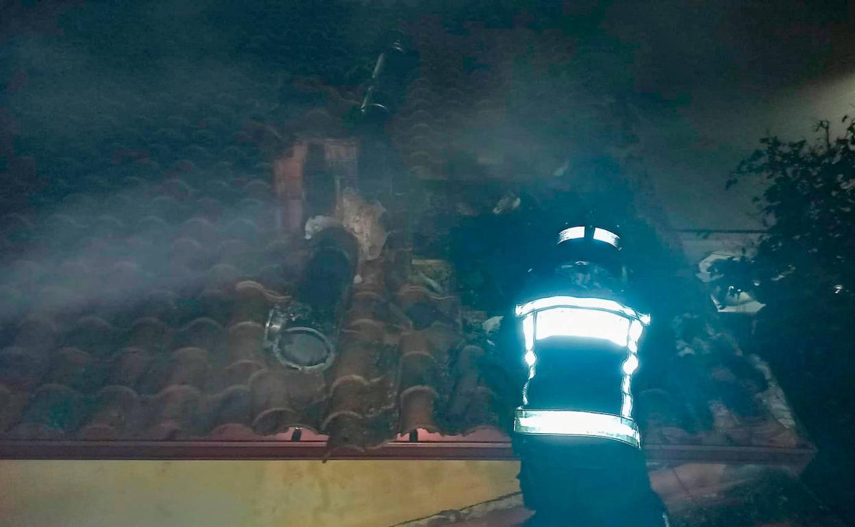 Imagen de los Bomberos de León en las tareas sobre el tejado de la vivienda. 