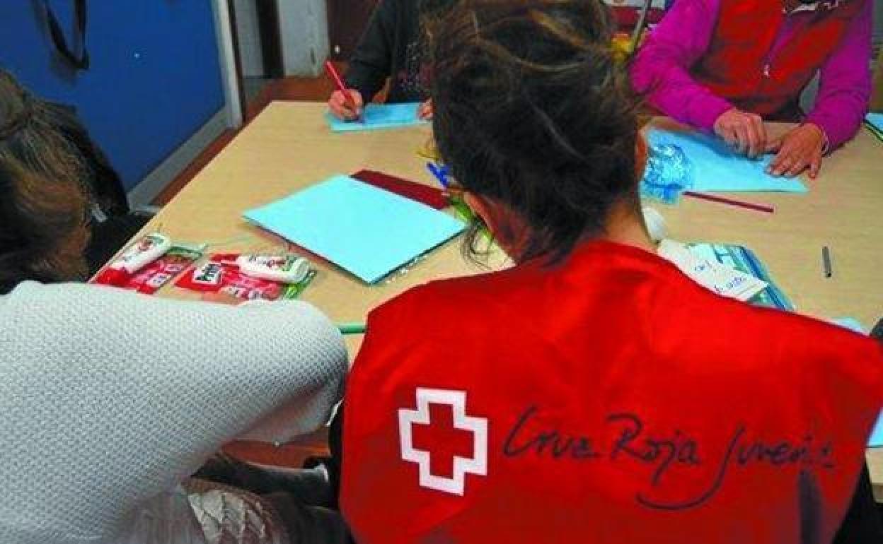 Una voluntaria de Cruz Roja realiza actividades con niños.