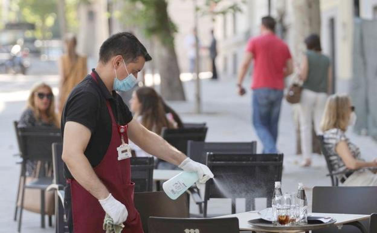 El sector servicios vuelve a aliviar los datos del paro en León. En la imagen, un camarero recoge una mesa durante los meses de pandemia.