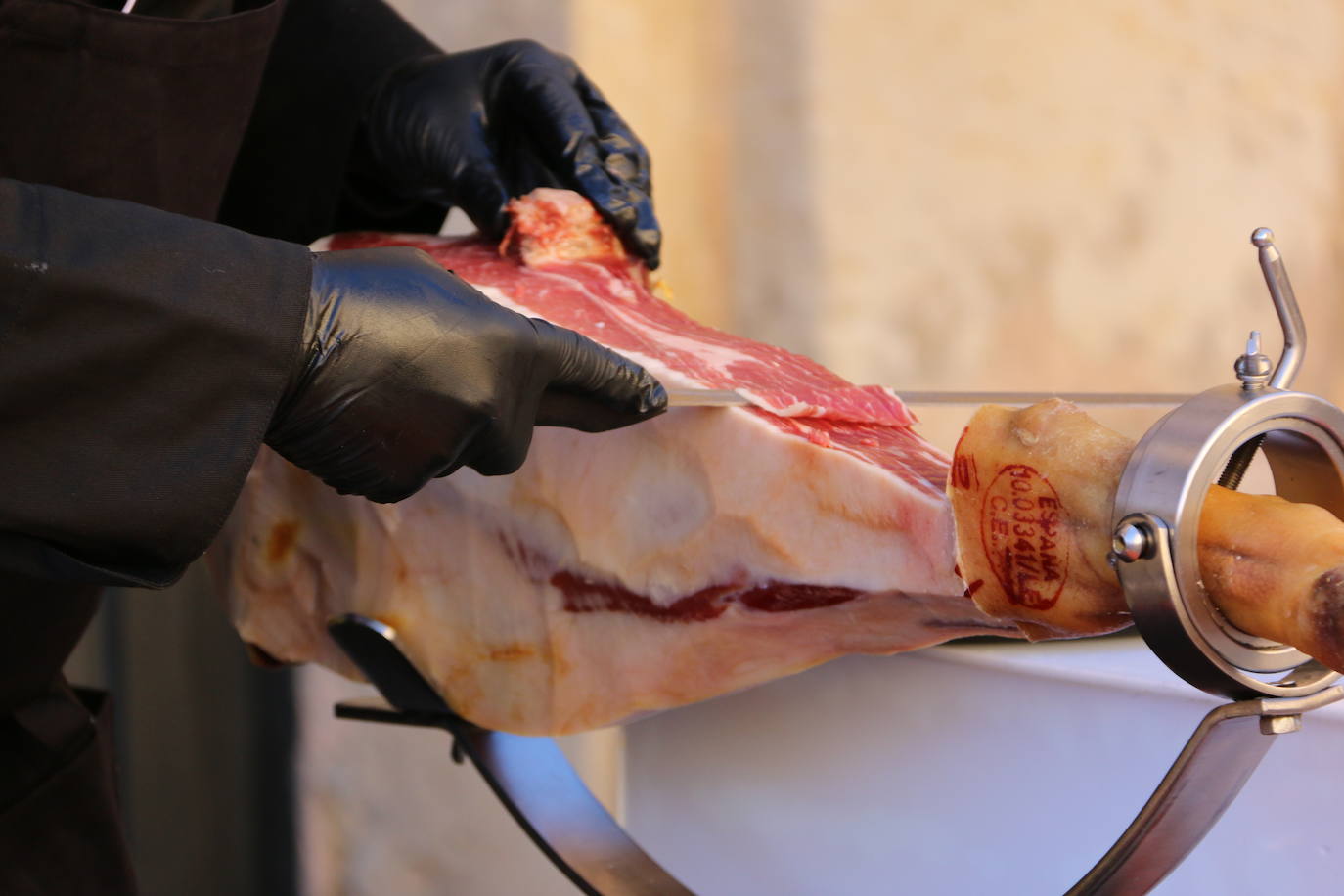 Centenares de personas participan en el corte de platos de jamón por una acción benéfica.