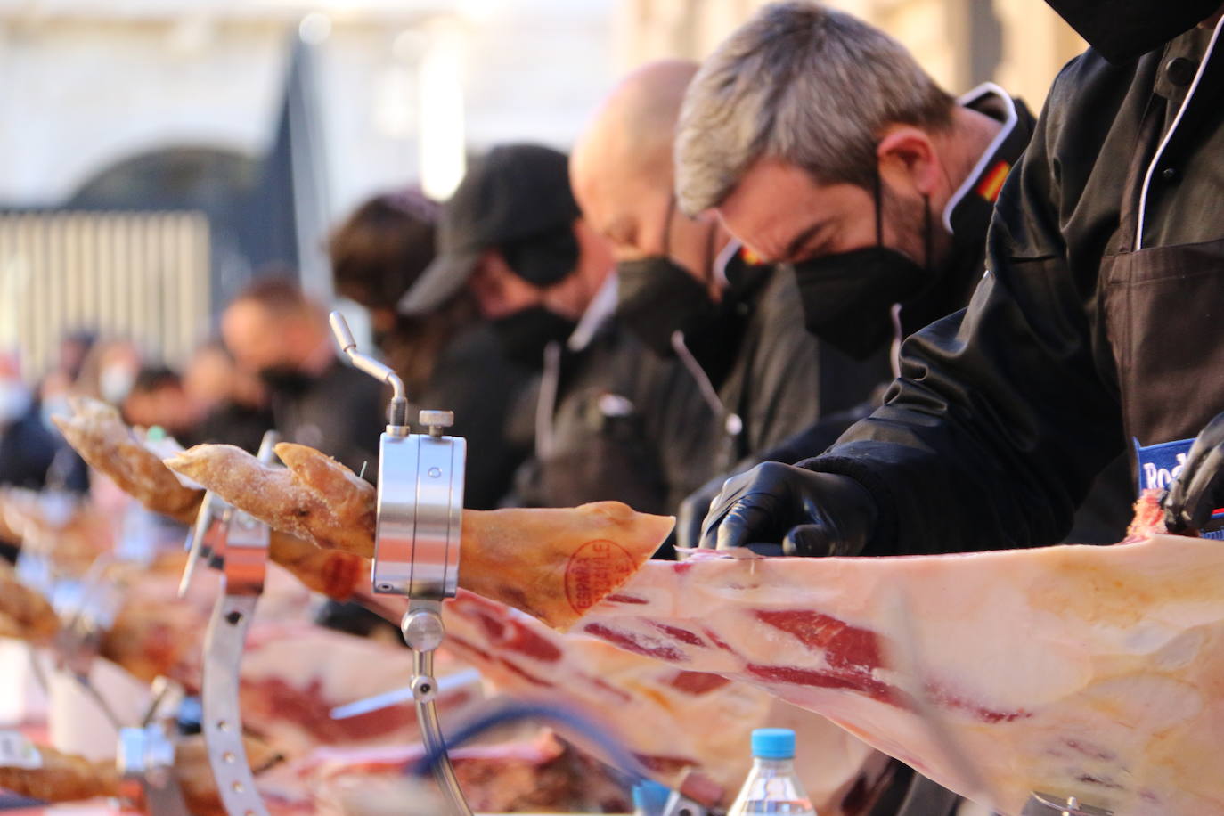 Centenares de personas participan en el corte de platos de jamón por una acción benéfica.