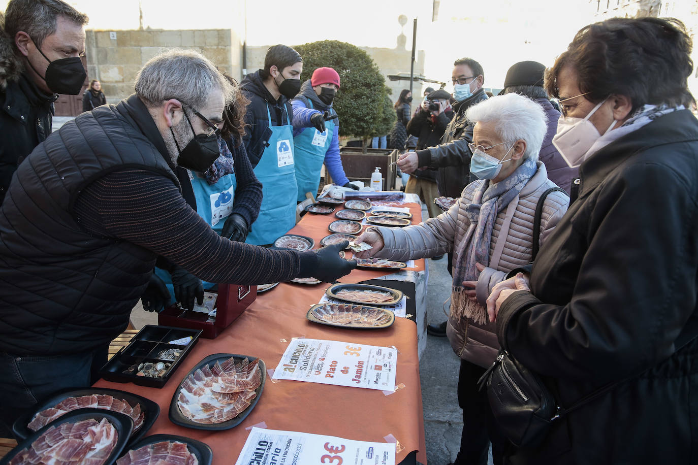 Centenares de personas participan en el corte de platos de jamón por una acción benéfica.