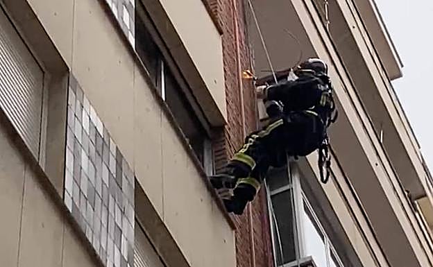 Imagen del bombero del cuerpo leonés desescalando por la fachada para acceder a la vivienda.