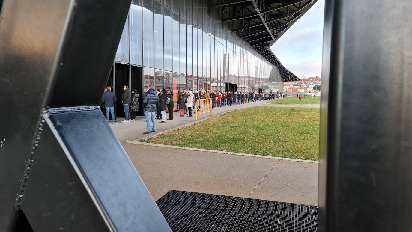 Una hora antes de la apertura de puertas en el 'vacunódromo' del Palacio de Exposiciones los leoneses 'de los 60' ya hacen cola para inocularse la tercera dosis | La cola, que ha llegado a alcanzar el kilómetro durante este martes, evidencia la alta respuesta al llamamiento. 