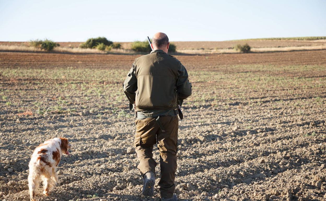 Un cazador junto a su perro. 