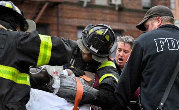 Los bomberos trasladan a uno de los heridos.