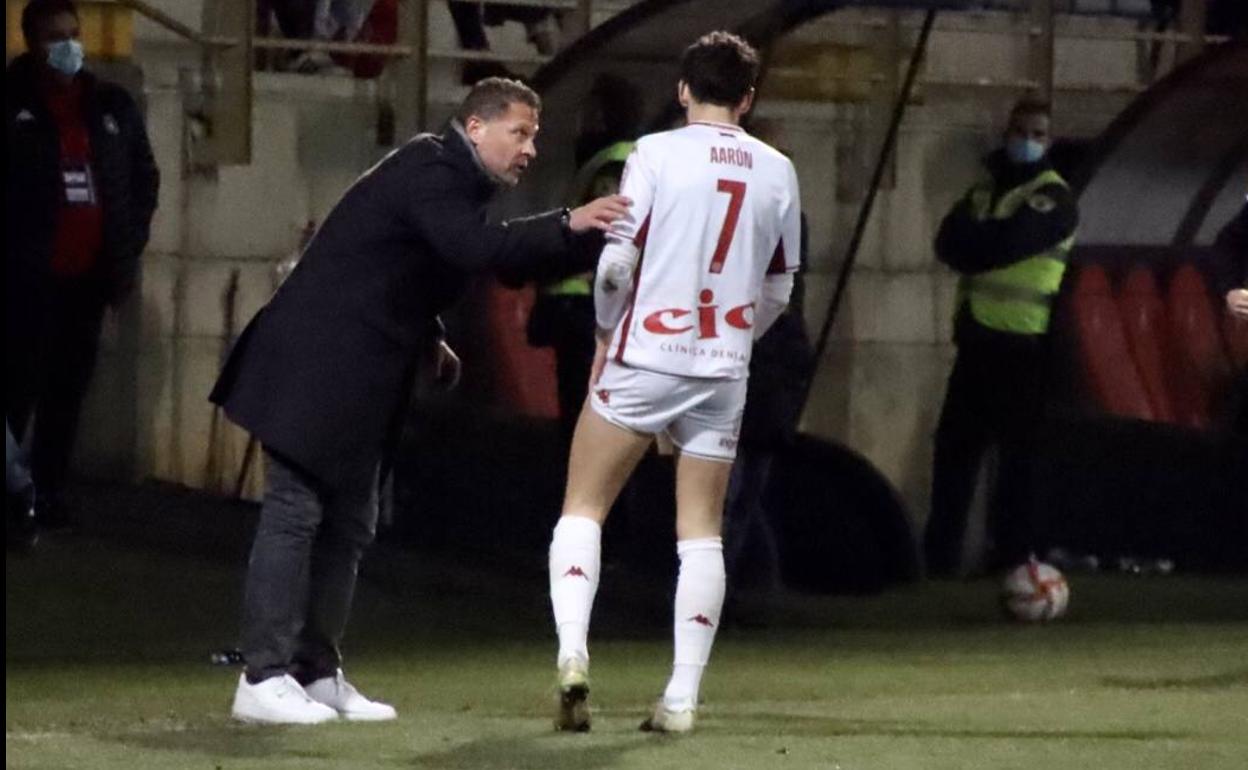 Curro Torres conversa con Aarón, que seguirá hasta final de temporada, en el partido ante el Badajoz.