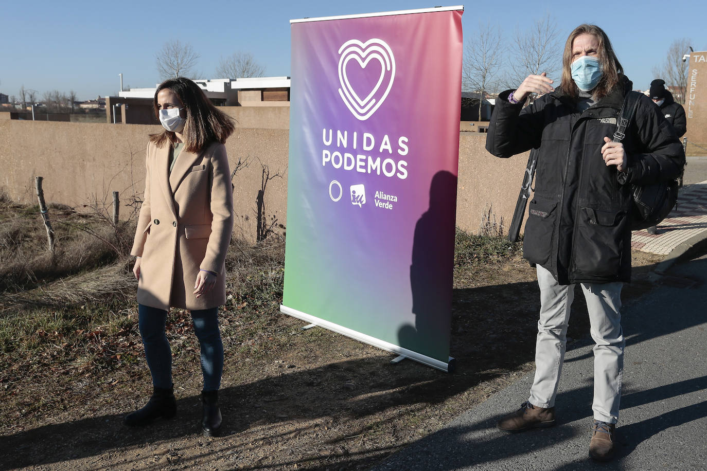 La secretaria general de Podemos y ministra de Derechos Sociales y Agenda 2030, Ione Belarra y el candidato a la Presidencia de Castilla y León, Pablo Fernández comparecen ante los terrenos en los que se construirá el nuevo instituto de Villaquilambre. Junto a ellos, el cabeza de lista por León, Sixto Martínez.