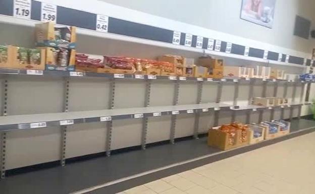 Estanterías de productos lácteos vacías en un supermercado Lidl de la capital. 