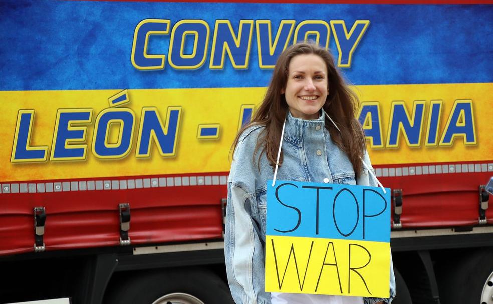 Un convoy solidario con el que colaboran varias empresas leonesas parte hacia la frontera de Eslovaquia y Ucrania, en la foto, una joven posa este domingo junto a un cartel pidiendo el fin de la guerra.