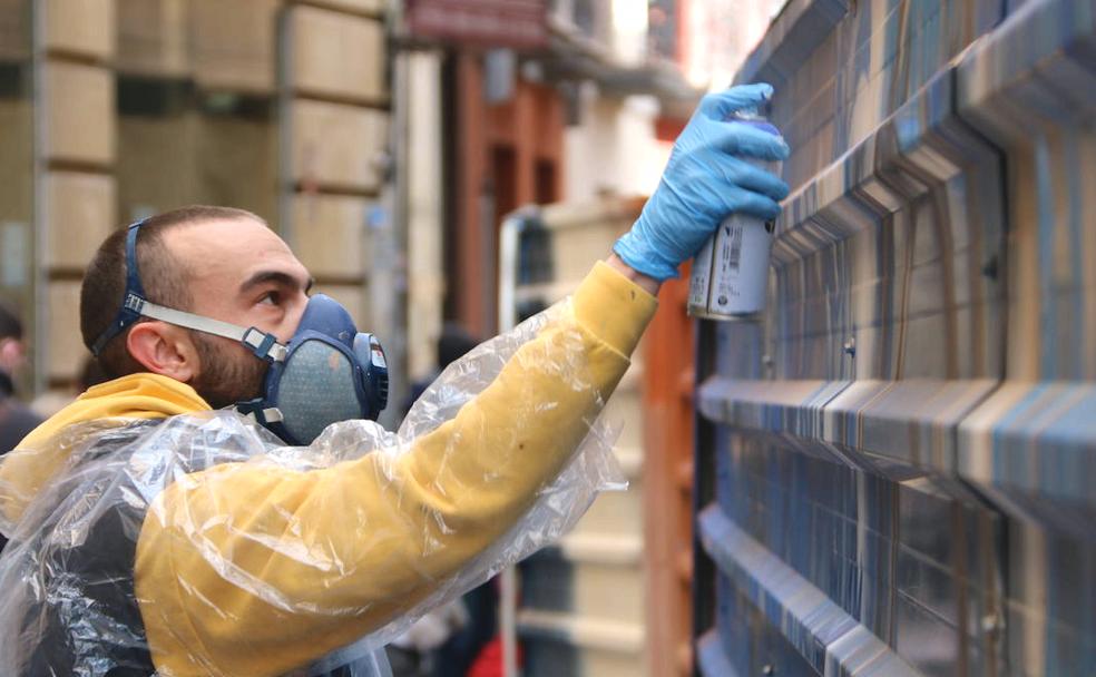 Uno de los participantes en el concurso mientras realiza su graffiti en la valla. 