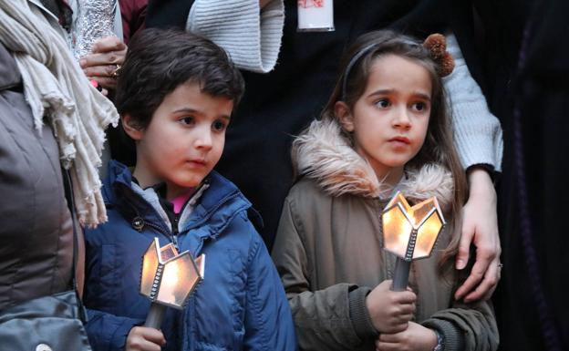 Galería. Dos niños portan una vela para acompañar a la Virgen.