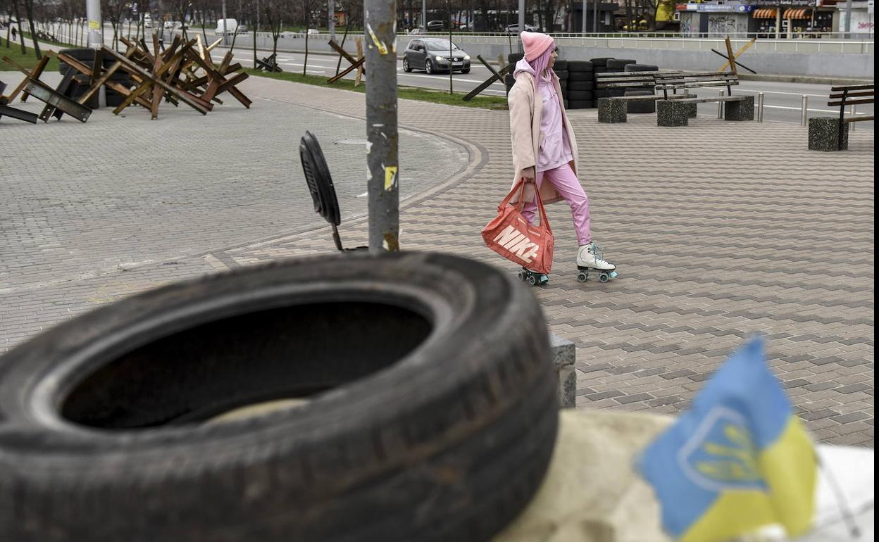 Una mujer patina en el centro de Kiev entre restos de barricadas.